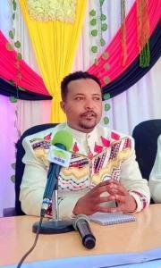 Ein Mann, der mit einem Mikrofon an einem Tisch sitzt. in der Unterkunft Keep it short and catchy in Nazrēt