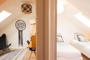 una camera da letto mansardata con due letti e una scrivania di Le Presbytère des Baraques à Blériot-Plage a Sangatte