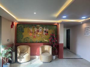 un dipinto sul muro in una hall con due sedie di Hotel AYODHYA HERITAGE a Ayodhya