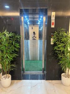 un ascensore in un edificio con due piante in vaso di Hotel AYODHYA HERITAGE a Ayodhya