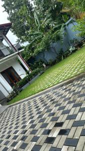 a house with a tiled driveway in front of a yard at Liya 