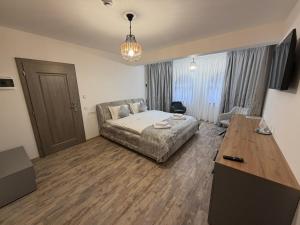 ein Wohnzimmer mit einem Bett und einem Tisch in der Unterkunft Pensiunea Seraris in Voineasa + 9 Fotos