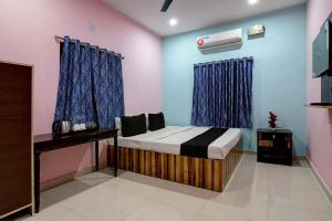 Un dormitorio con cama, escritorio y televisión. en Hotel O AMULYA AASHIYANA, en Bhubaneshwar 22 fotos más
