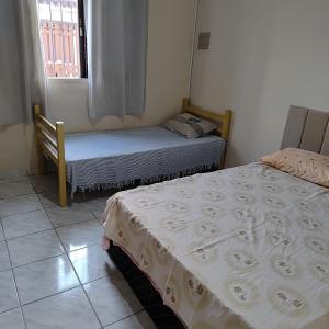 two twin beds in a room with a window at Casa com piscina Mongaguá 2 quartos in Mongaguá +89 photos