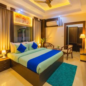 Un dormitorio con una cama grande con almohadas azules. en Hotel Ramawati Classic, A Luxury Hotel & Resort, Haridwar, en Haridwar