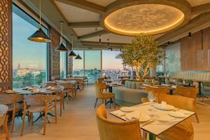 ein Restaurant mit Tischen und Stühlen und Blick auf die Stadt in der Unterkunft Ribera de Triana Hotel in Sevilla