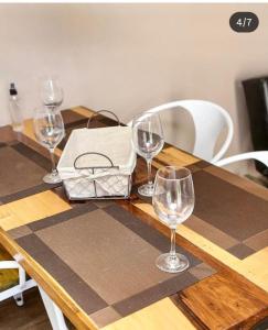 a wooden table with four wine glasses on it at Campo Galano in Miramar +7 photos