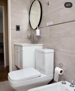 a bathroom with a toilet and a mirror and a sink at Campo Galano in Miramar