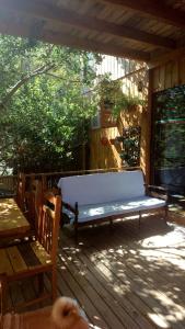 a white bench sitting on a wooden deck at Maia House Hostal in Florianópolis