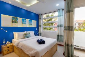 a blue bedroom with a bed and a window at Coming Soon in Hulhumale