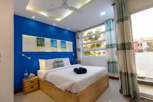 a blue bedroom with a large bed with a blue wall at Coming Soon in Hulhumale +6 photos