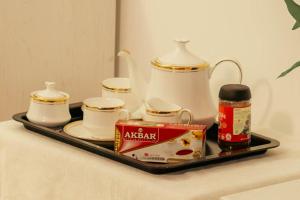 una bandeja con una tetera y tazas sobre una mesa en Coming Soon, en Hulhumale