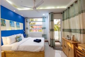 Un dormitorio con una cama grande con una pared azul. en Coming Soon, en Hulhumale