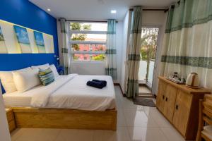 a bedroom with a large bed with a blue wall at Coming Soon in Hulhumale