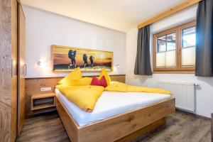a bedroom with a bed with yellow and red pillows at AlpenLiving in Mayrhofen