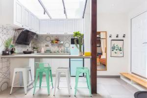 Una cocina con gabinetes blancos y taburetes verdes. en Shanghai Hills&XING 593 Homestay Mid Huaihai Rd Near Metro Line 1 North Zhongshan Rd, en Shanghái