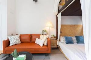 una sala de estar con un sofá y una cama en Shanghai Hills&XING 593 Homestay Mid Huaihai Rd Near Metro Line 1 North Zhongshan Rd, en Shanghái