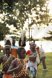 un grupo de personas de pie en un campo en Majik Resort Beach, en Busia