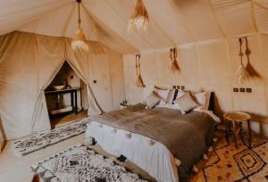 a bedroom with a bed in a tent at Sandrock Luxury Camp in Merzouga