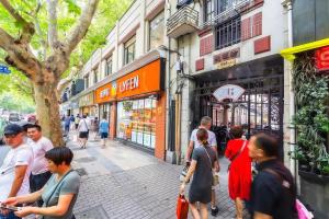 un grupo de personas caminando por una calle de la ciudad en Shanghai Hills&XING 593 Homestay Mid Huaihai Rd Near Metro Line 1 North Zhongshan Rd, en Shanghái