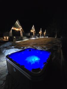 兹拉蒂博尔ZEN Luxury Houses & Spa的浴缸,晚上里面装有蓝色液体