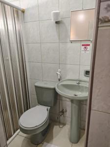 a small bathroom with a toilet and a sink at Hotel Val-de-Cans Aeroporto in Belém