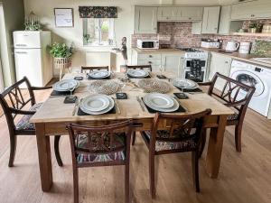 een houten tafel in een keuken met stoelen en een tafel bij Talltrees - Uk42842 in Uplowman
