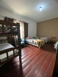 ein Schlafzimmer mit zwei Etagenbetten und Holzboden in der Unterkunft Pousada Villas in Sorocaba