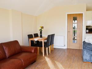 a living room with a couch and a table and chairs at Hawthorne Cottage in Winthorpe