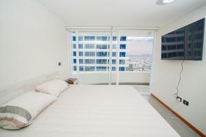 En eller flere senge i et værelse på Departamento Distrito 1 Cavancha Piso 19 + 16 billeder