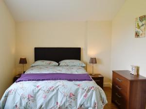 a bedroom with a bed and a dresser at Hawthorne Cottage in Winthorpe