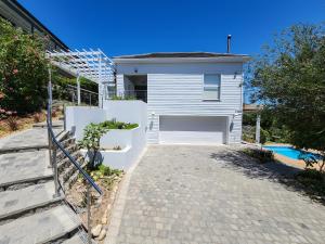 una casa bianca con un garage e un vialetto d'accesso di Living Lagoon Two Apartments a Brenton-on-Sea