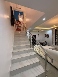 a staircase in a living room with a couch at Quantum Havens Apartment - LISBON in Akure