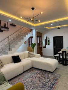 a living room with a white couch and a staircase at Quantum Havens Apartment - LISBON in Akure