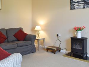 een woonkamer met een bank en een fornuis bij Elm Court 7 in Keswick
