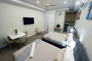 Una habitación de hotel con dos camas y una mesa y una cocina. en Harbour Retreat, en Hayborough 12 fotos más