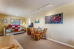 a living room with a table and chairs and a bedroom at On the Rapids - A Unit in Grand Lake