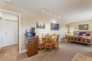 a room with a bed and a table with a microwave at On the Rapids - A Unit in Grand Lake +29 photos