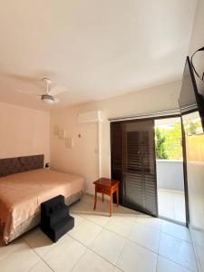 een slaapkamer met een bed, een tafel en een raam bij King Midas in Guarujá