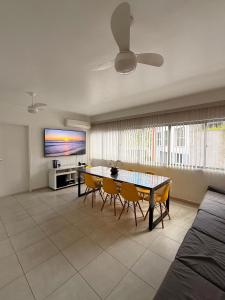 een woonkamer met een tafel en stoelen en een televisie bij King Midas in Guarujá +9 foto's