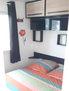a bedroom with a bed and a window at Mobil home proche Fréjus - Camping 4 étoiles in Puget-sur-Argens +11 photos