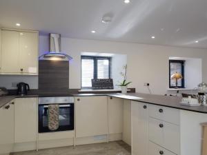 una cucina con mobili bianchi e una stufa di Cider Mill a Bullingham Altre 12 foto