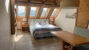 a bedroom with a bed in a room with windows at Hotel Friedheim Weggis in Weggis