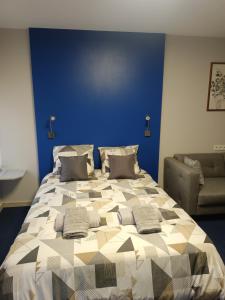 een slaapkamer met een groot bed en een bank bij Le nid in Colmar