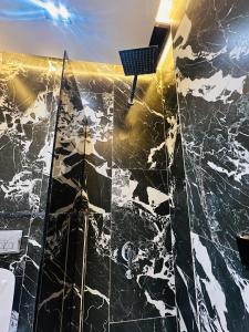 卢克索Farida Palace Hotel的一间带黑色大理石淋浴间的浴室