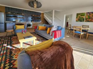 un soggiorno con un divano blu e un tavolo di Living Lagoon Two Apartments a Brenton-on-Sea