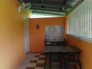ein Esszimmer mit einem Holztisch und Stühlen in der Unterkunft Khanom Garden Suite in Khanom