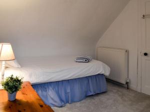 Cama en habitación con mesa y lámpara en Jebel, en Cullen 8 fotos más