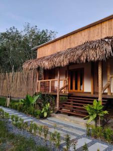 a house with a thatched roof and stairs in front at Painon Resort KohLanta in Ko Bu Bu