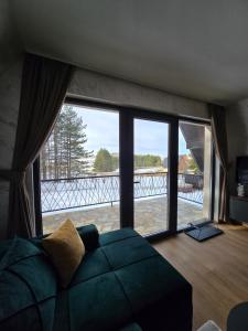 兹拉蒂博尔ZEN Luxury Houses & Spa的带沙发和大窗户的客厅